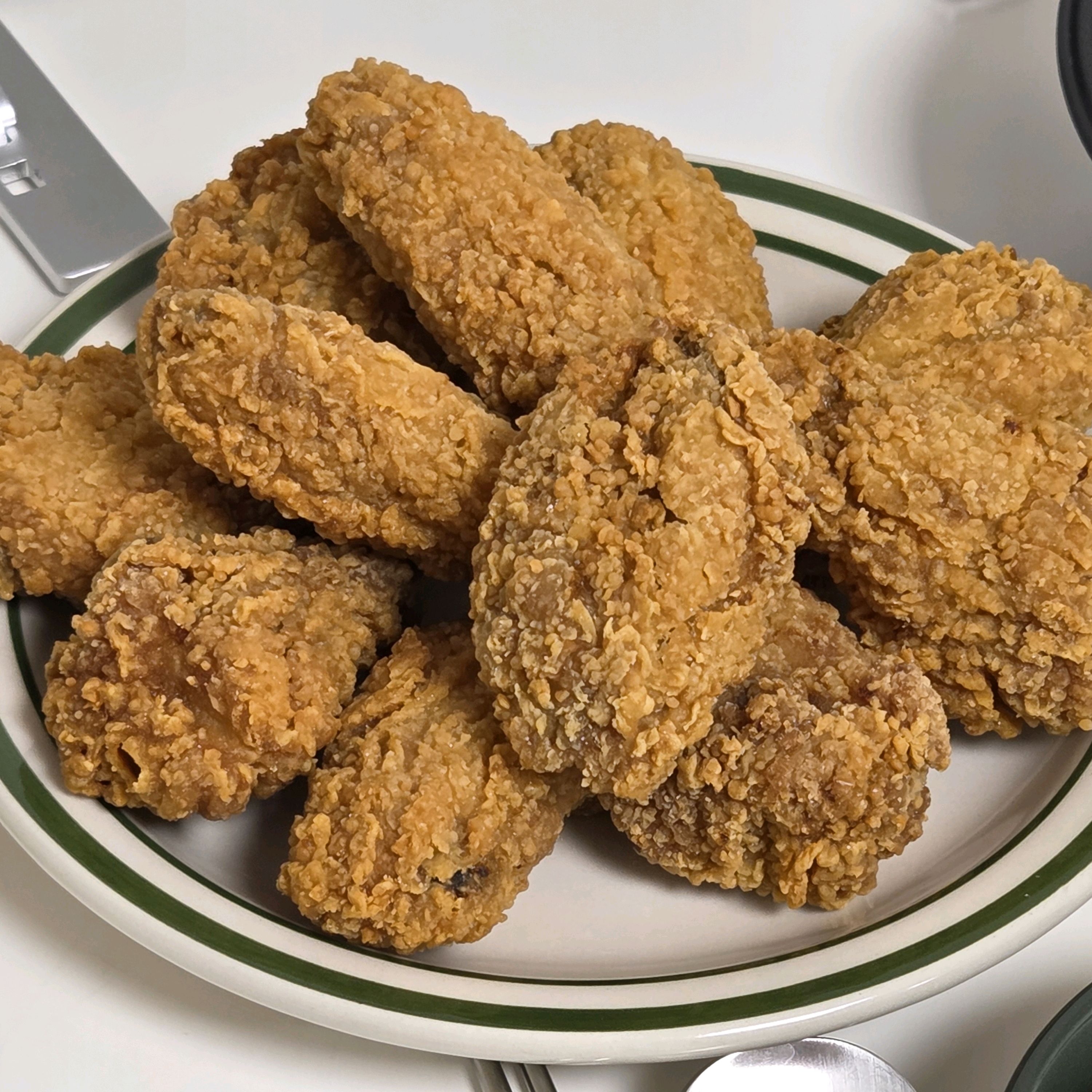 초록색 테두리 접시에 바삭한 튀김 음식이 담겨 있다