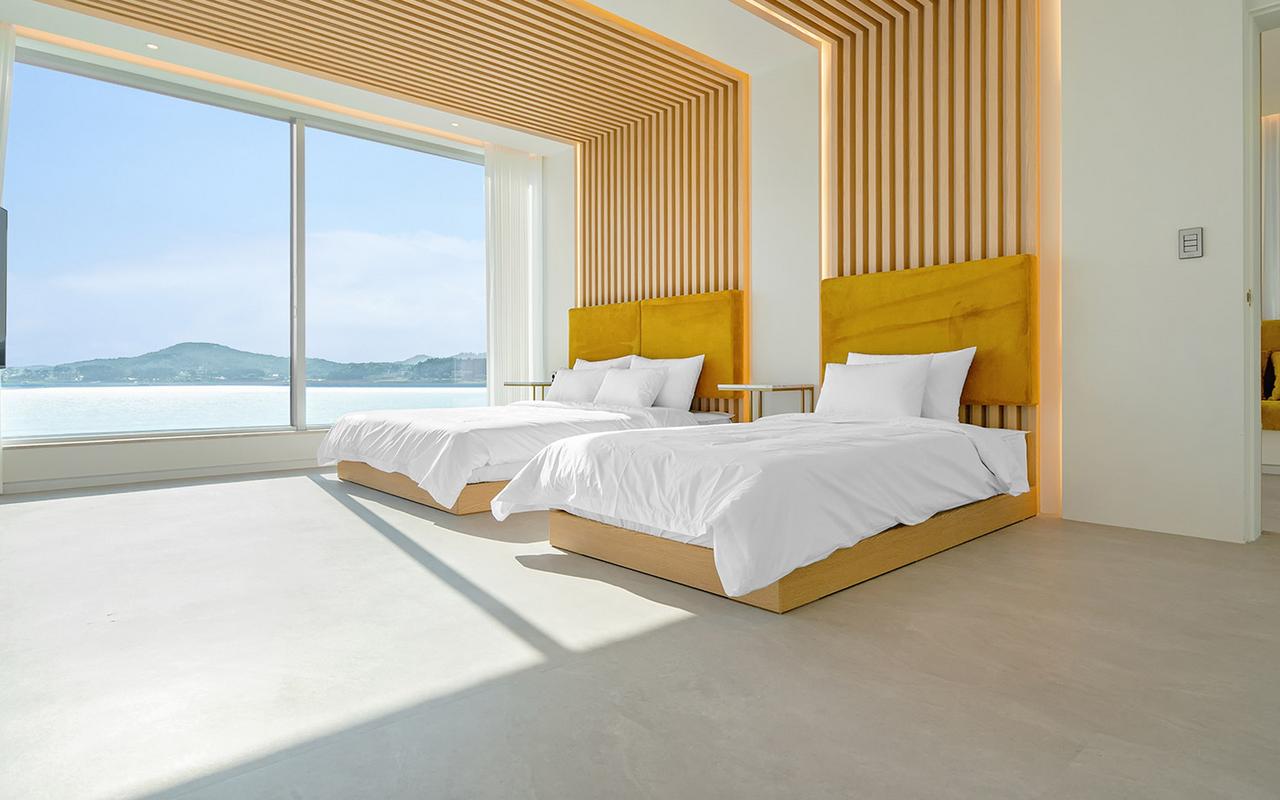큰 창으로 수변 풍경이 보이는 침대 두 개가 있는 침실